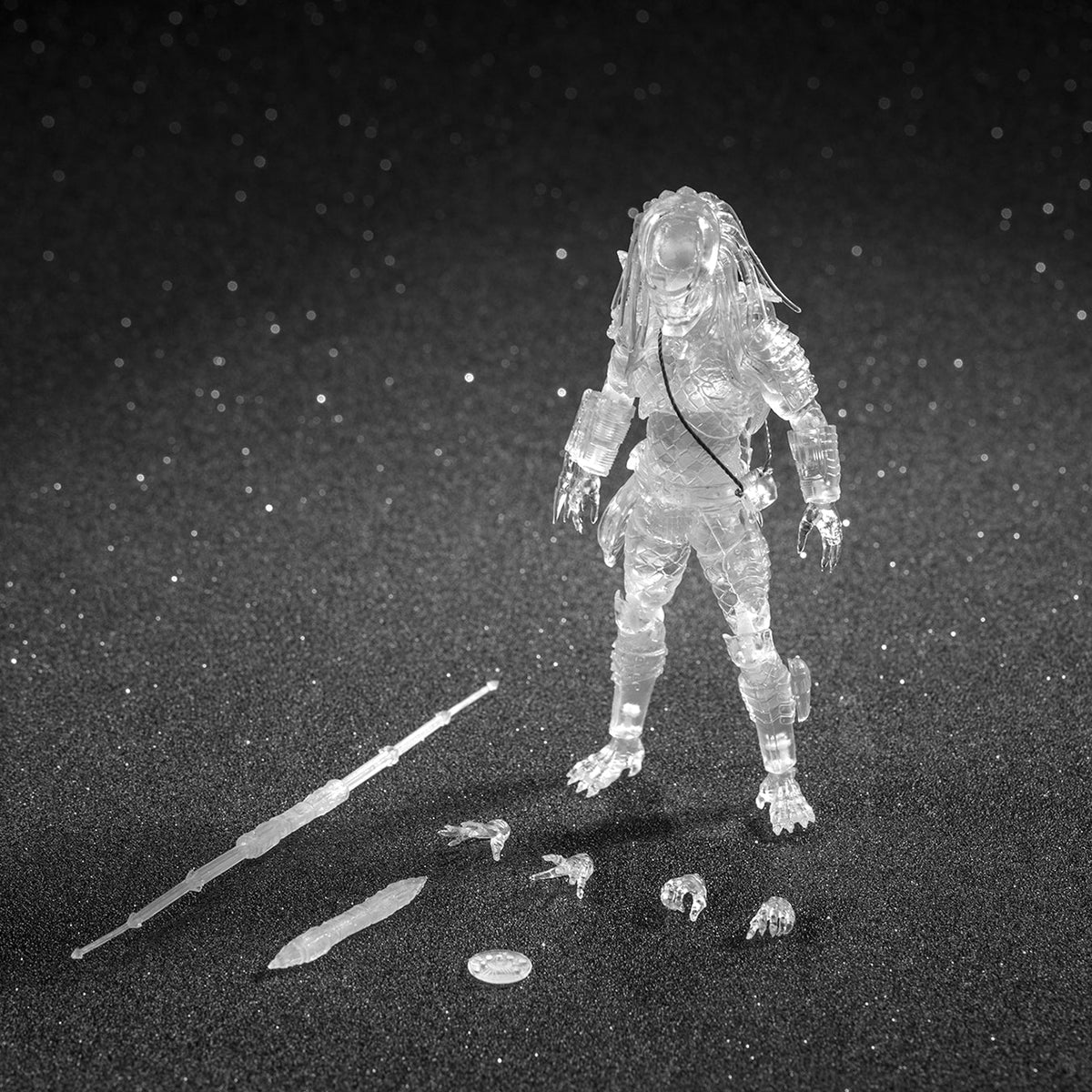 clear action figure with weapon on a dark background