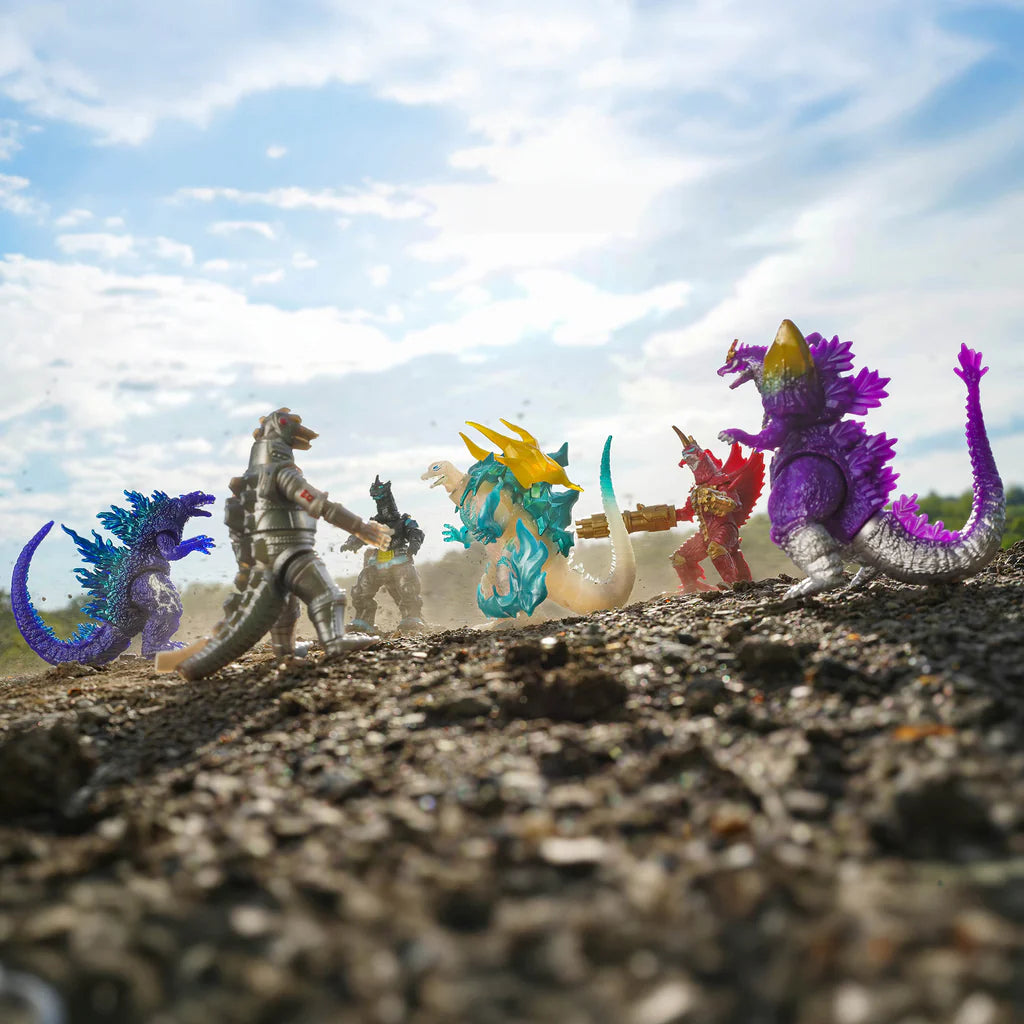 Colorful Kaiju toy figures on a textured surface with a blue sky background - Action Figures - Movies - Godzilla & Kong