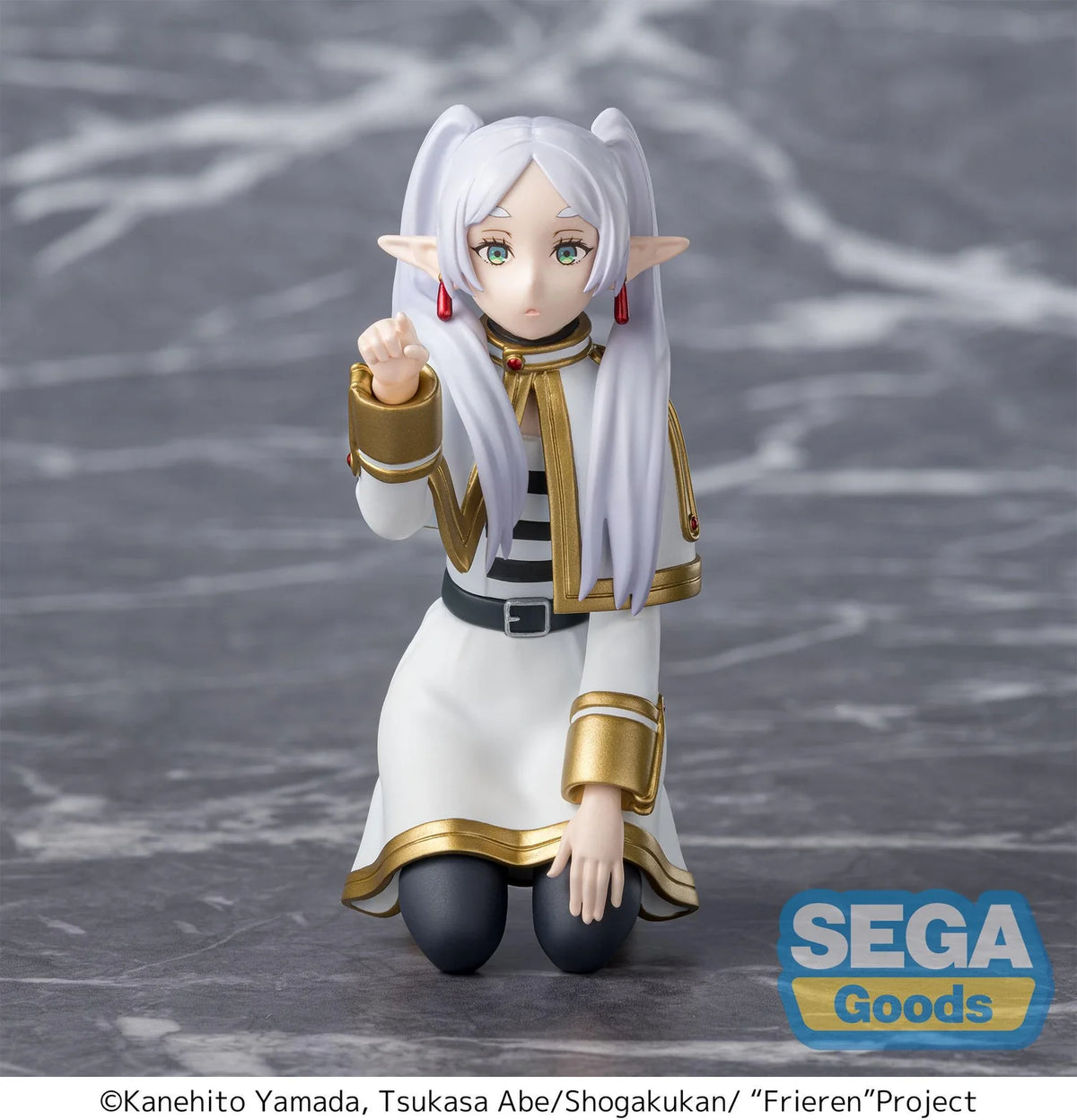 Frieren Figurine of an elf-like character in a white and gold outfit on a gray background with 'Sega Goods' logo.