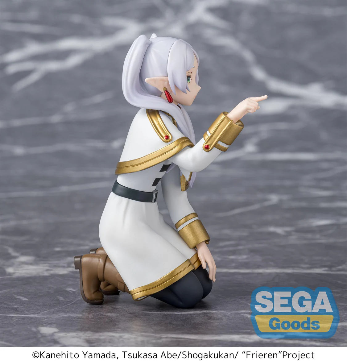 A kneeling anime figurine of a female elf with white hair in a ponytail, wearing a white and gold uniform with dark pants, posed against a gray marble-like background. A SEGA Goods logo appears in the lower right.