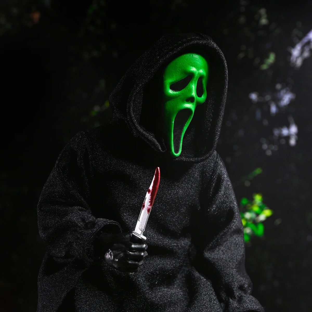 Person wearing a dark hoodie and green mask holding a knife with a dark background - Action Figures - Horror
