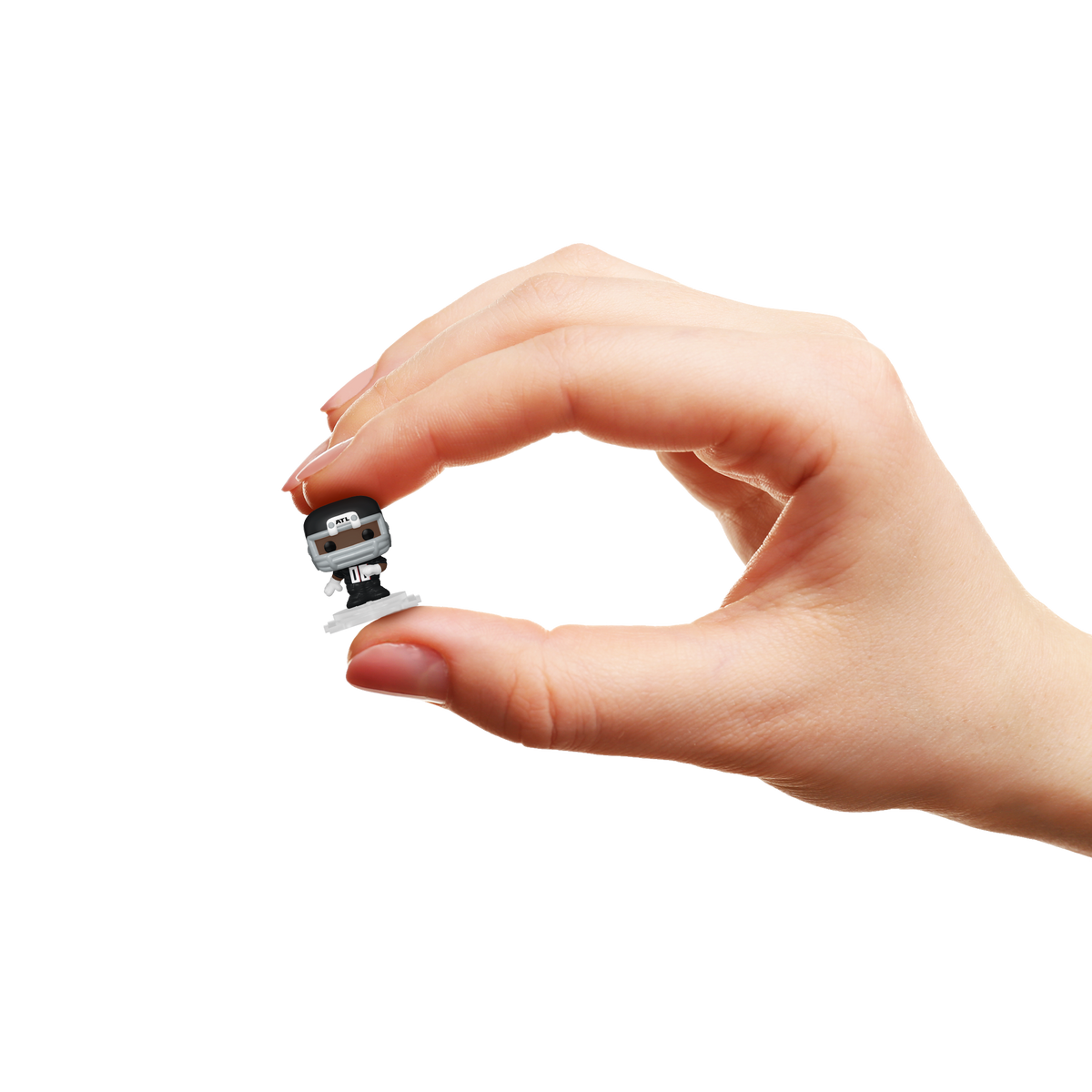 Hand holding a miniature Atlanta Falcons Bitty Pop! player in a black helmet and football uniform.