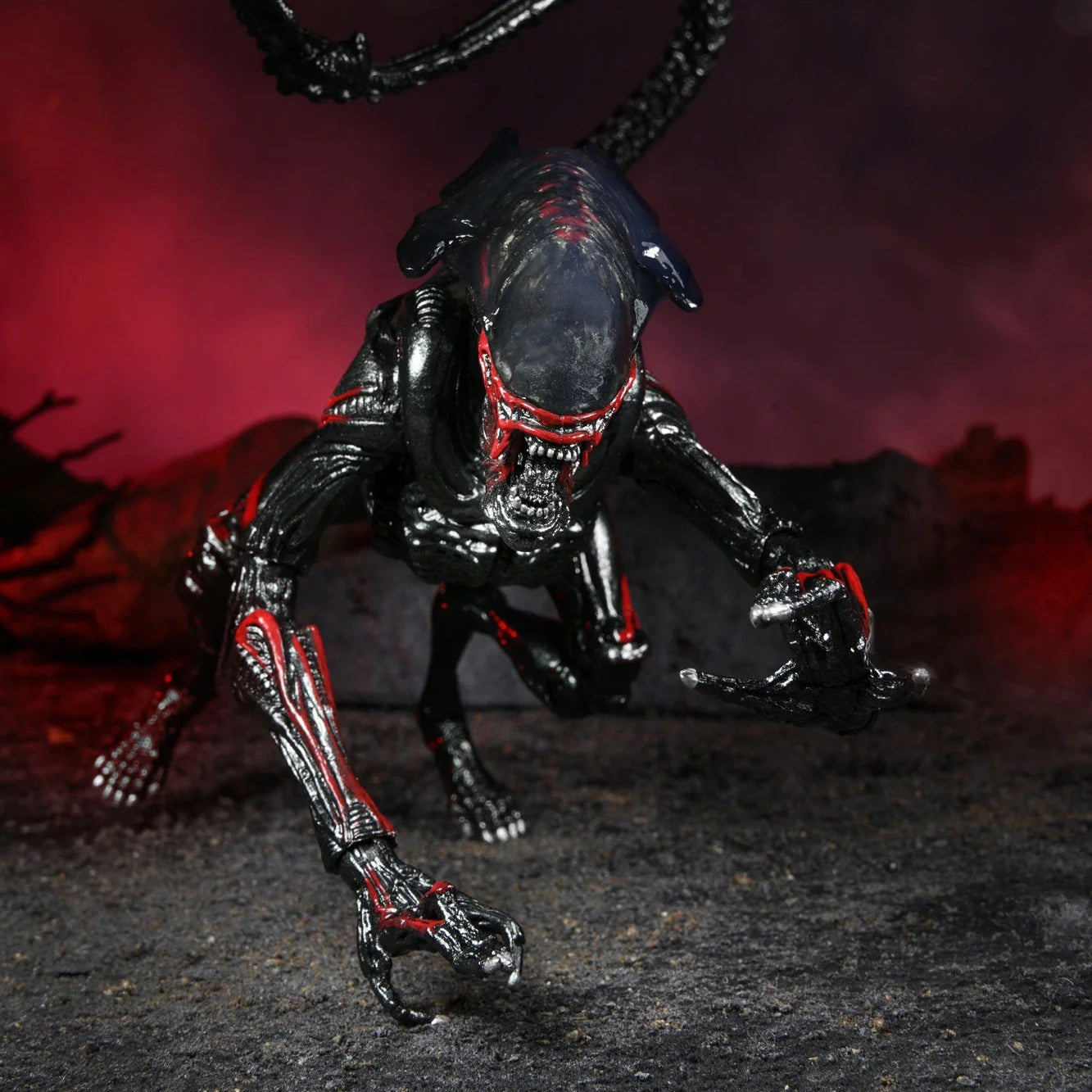 Black and red alien-like creature figure with a dark background