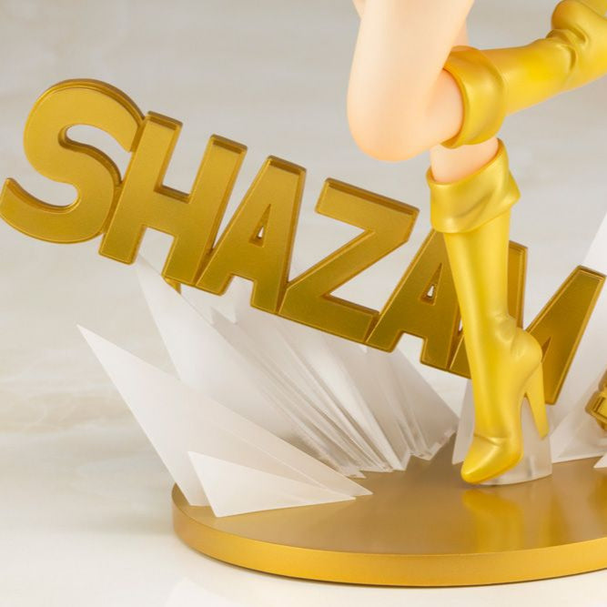 Figurine with yellow boots and 'SHAZAM!' letters on a white background